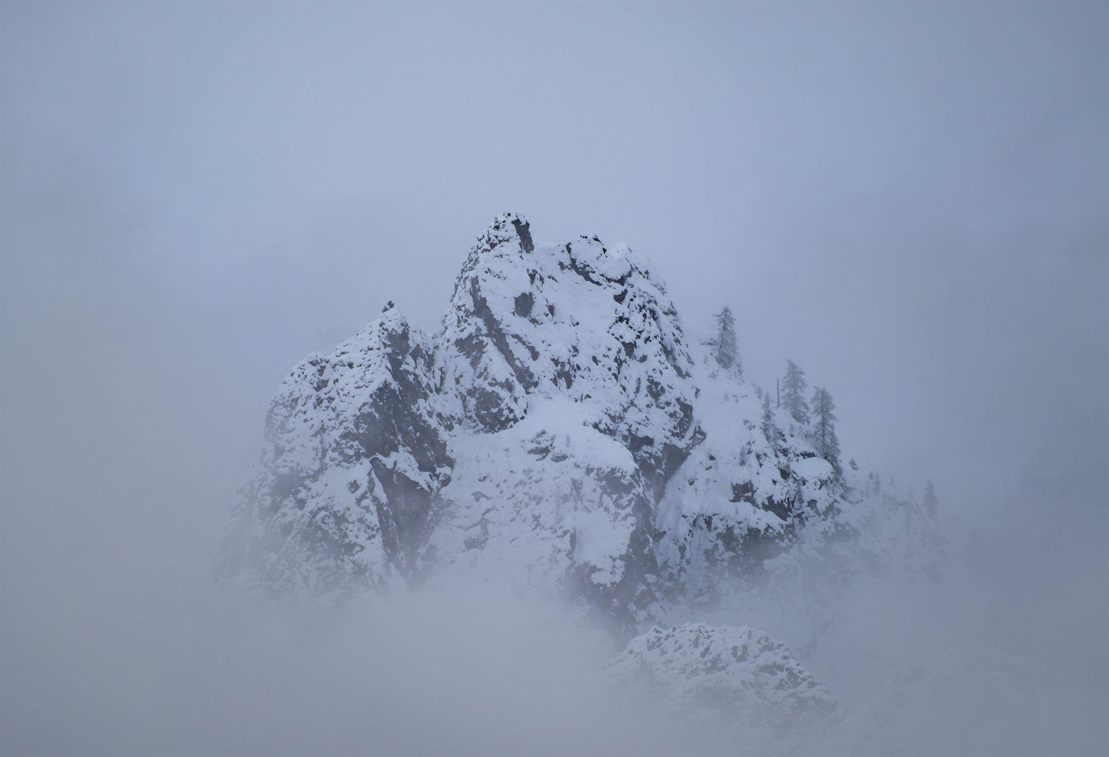 Snow-capped peak breaking through low fog